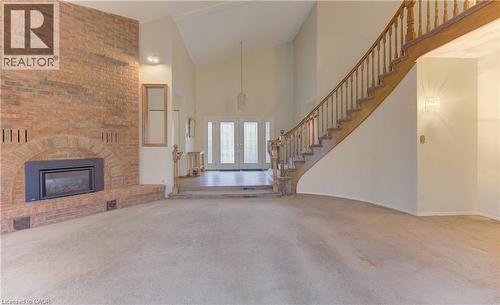 Unfurnished living room featuring vaulted ceiling, carpet, a brick fireplace, and french doors - 190 Silvercrest Drive, Waterloo, ON - Indoor With Fireplace