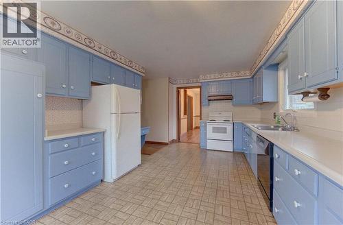 Kitchen with blue cabinets, white appliances, brick patterned flooring, and light countertops - 190 Silvercrest Drive, Waterloo, ON - Indoor Photo Showing Kitchen With Double Sink