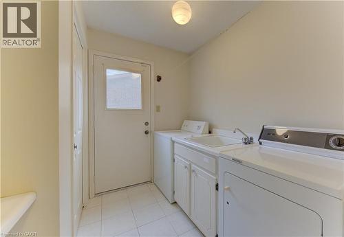 Laundry area with light tile patterned floors, washer and dryer, and cabinet space - 190 Silvercrest Drive, Waterloo, ON - Indoor Photo Showing Laundry Room