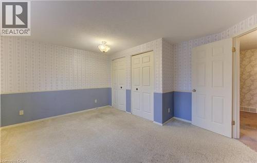 Unfurnished bedroom with carpet, two closets, and a textured ceiling - 190 Silvercrest Drive, Waterloo, ON - Indoor Photo Showing Other Room