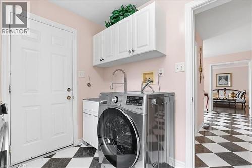 Laundry area featuring dark floors, washer / dryer, and cabinet space - 54 Woodcrest Court, Kitchener, ON - Indoor Photo Showing Laundry Room
