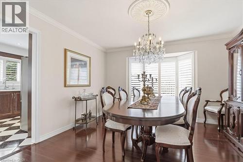 Dining room featuring ornamental molding, dark wood-type flooring, and hanging lights - 54 Woodcrest Court, Kitchener, ON - Indoor Photo Showing Dining Room