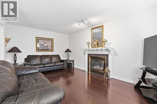 Living area with dark wood-type flooring, track lighting, and a fireplace - 54 Woodcrest Court, Kitchener, ON - Indoor Photo Showing Living Room With Fireplace