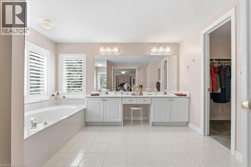 Bathroom featuring double vanity, a walk in closet, a bath, and light tile patterned floors - 54 Woodcrest Court, Kitchener, ON - Indoor Photo Showing Bathroom