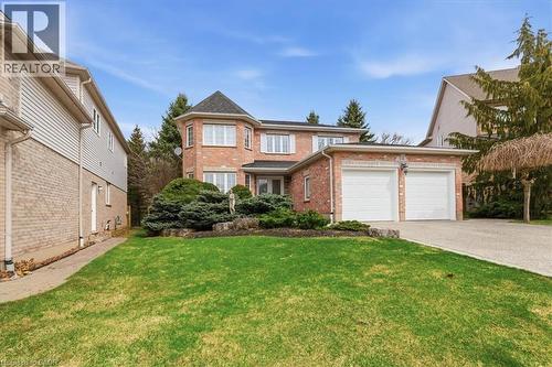 Traditional-style house with an attached garage, brick siding, driveway, and a front yard - 54 Woodcrest Court, Kitchener, ON - Outdoor