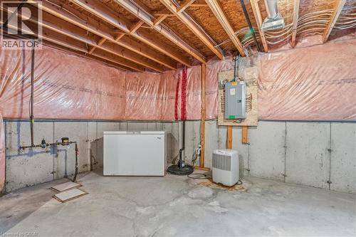 Unfinished below grade area with white refrigerator, electric panel, and drainage system - 54 Woodcrest Court, Kitchener, ON - Indoor Photo Showing Basement