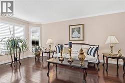 Living room featuring dark wood-type flooring and ornamental molding - 