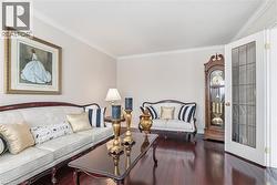 Living area with ornamental molding and dark wood finished floors - 
