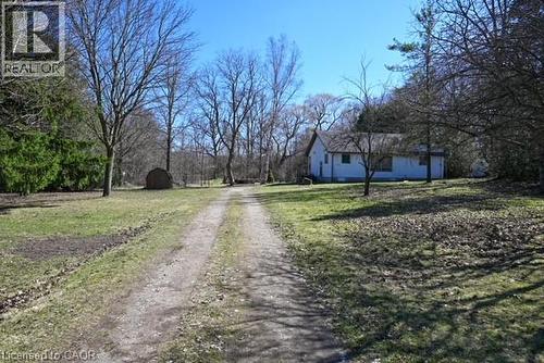 View of dirt / gravel driveway featuring view of wooded area - 1145 Main Street, Cambridge, ON 
