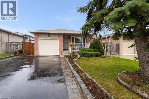 Ranch-style house with brick siding, asphalt driveway, and an attached garage - 51 Independence Drive, Hamilton, ON - Outdoor With Deck Patio Veranda