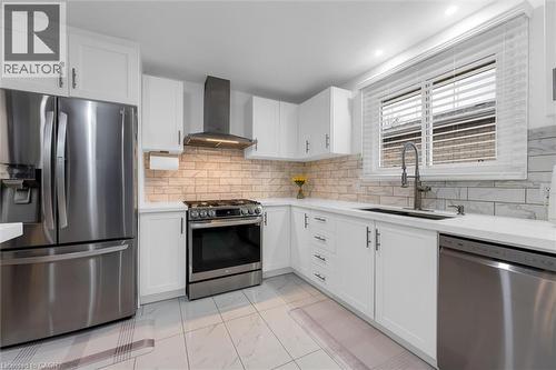 Kitchen with stainless steel appliances, light marble finish floors, white cabinets, and tasteful backsplash - 51 Independence Drive, Hamilton, ON - Indoor Photo Showing Kitchen