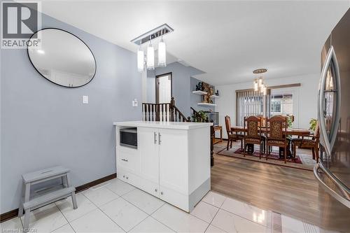 Kitchen featuring stainless steel appliances, white cabinets, a peninsula, light countertops, and suspended lighting - 51 Independence Drive, Hamilton, ON - Indoor