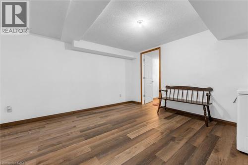 Bonus room with a textured ceiling and dark wood-style floors - 51 Independence Drive, Hamilton, ON - Indoor Photo Showing Other Room