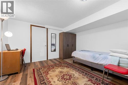 Bedroom featuring dark wood-type flooring, a textured ceiling, and a desk - 51 Independence Drive, Hamilton, ON - Indoor Photo Showing Bedroom