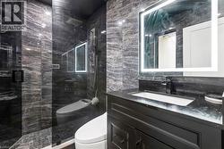 Full bathroom with tile walls, vanity, and a marble finish shower - 