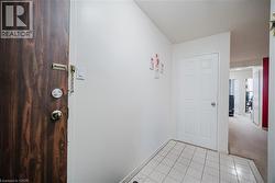 Hall with light tile patterned flooring and a textured ceiling - 
