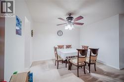 Dining area with light carpet and a ceiling fan - 