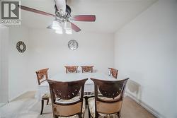 Dining room featuring a ceiling fan and light carpet - 