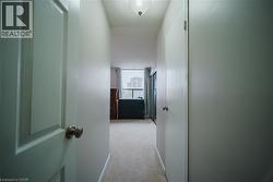 Corridor with light colored carpet and a textured ceiling - 