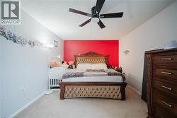 Bedroom with light carpet and a ceiling fan - 