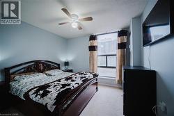 Bedroom featuring light colored carpet, a ceiling fan, and a textured ceiling - 
