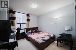 Bedroom with light colored carpet, a desk, and a textured ceiling - 