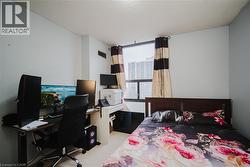 Bedroom featuring an office area, a textured ceiling, and light carpet - 