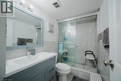 Bathroom featuring vanity, a shower stall, and tile walls - 