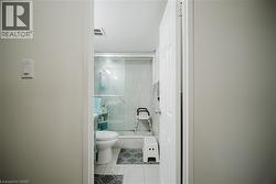 Bathroom with a shower stall and light tile patterned floors - 