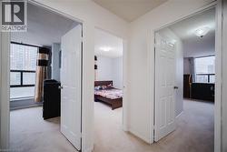 Corridor featuring light colored carpet and a textured ceiling - 