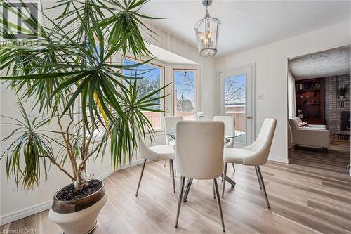 Dining space featuring light wood finished floors, suspended lighting, and a fireplace - 488 Heather Hill Place, Waterloo, ON - Indoor Photo Showing Dining Room
