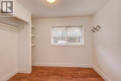 Walk in closet for primary suite featuring light wood-style floors - 