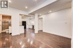 Main floor living room with dark wood-style flooring and recessed lighting - 