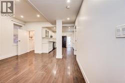 Main floor living room featuring dark wood-style floors and recessed lighting - 