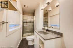 Main floor full bathroom with vanity and a shower stall - 