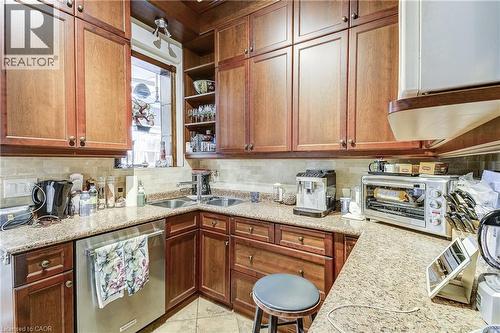 Kitchen with dishwasher, open shelves, tasteful backsplash, and light stone counters - 315 Aberdeen Avenue, Hamilton, ON - Indoor Photo Showing Kitchen With Double Sink
