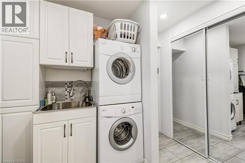 Laundry room featuring stacked washing machine and dryer and cabinet space - 315 Aberdeen Avenue, Hamilton, ON - Indoor Photo Showing Laundry Room