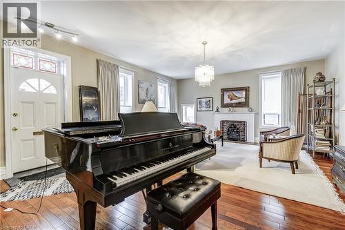 Sitting room featuring hardwood / wood-style flooring, a fireplace, and suspended lighting - 315 Aberdeen Avenue, Hamilton, ON - Indoor With Fireplace
