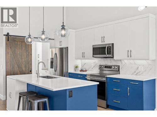 A large island provides ample counter space - 1860 Blue Bunch Court, Kelowna, BC - Indoor Photo Showing Kitchen With Double Sink With Upgraded Kitchen