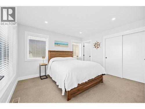 Main floor primary bedroom - 1860 Blue Bunch Court, Kelowna, BC - Indoor Photo Showing Bedroom