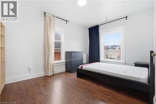 Bedroom with dark wood finished floors and multiple windows - 30 Regina Street N, Waterloo, ON 