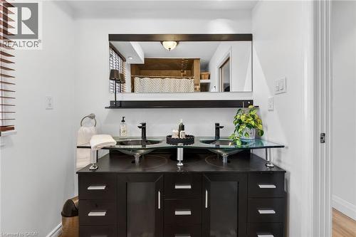 Bathroom with double vanity, a shower with curtain, and wood finished floors - 844 Upper Wellington Street, Hamilton, ON - Indoor Photo Showing Other Room