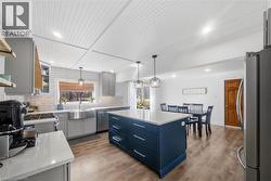 Kitchen with stainless steel appliances, light wood-style floors, a kitchen island, and backsplash - 