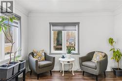 Sitting room featuring wood finished floors and crown molding - 
