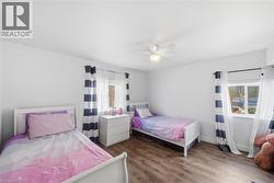 Bedroom with dark wood-style flooring and a ceiling fan - 