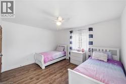 Bedroom featuring dark wood finished floors and ceiling fan - 