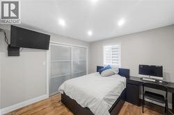 Bedroom featuring light wood-type flooring and baseboards - 