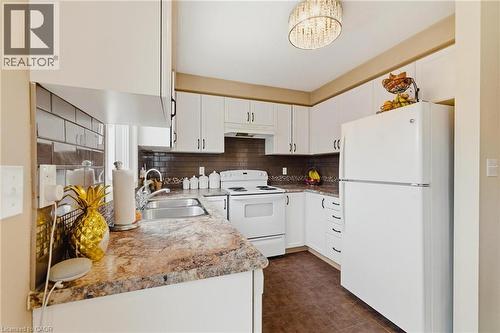 Kitchen featuring white appliances, white cabinets, light countertops, and backsplash - 750 Lawrence Street Unit# 88, Cambridge, ON - Indoor Photo Showing Kitchen With Double Sink