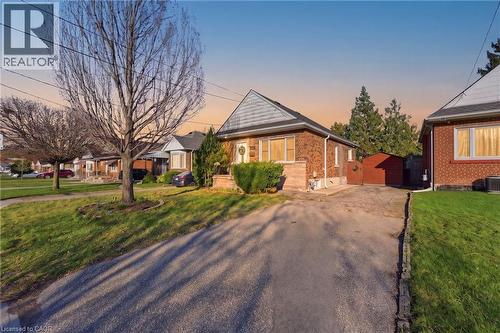 View of front of property featuring a front lawn, brick siding, an outdoor structure, a residential view, and driveway - 171 Glencairn Avenue, Hamilton, ON - Outdoor