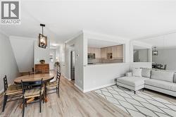 Dining space with suspended lighting, light wood-style floors, and ornamental molding - 